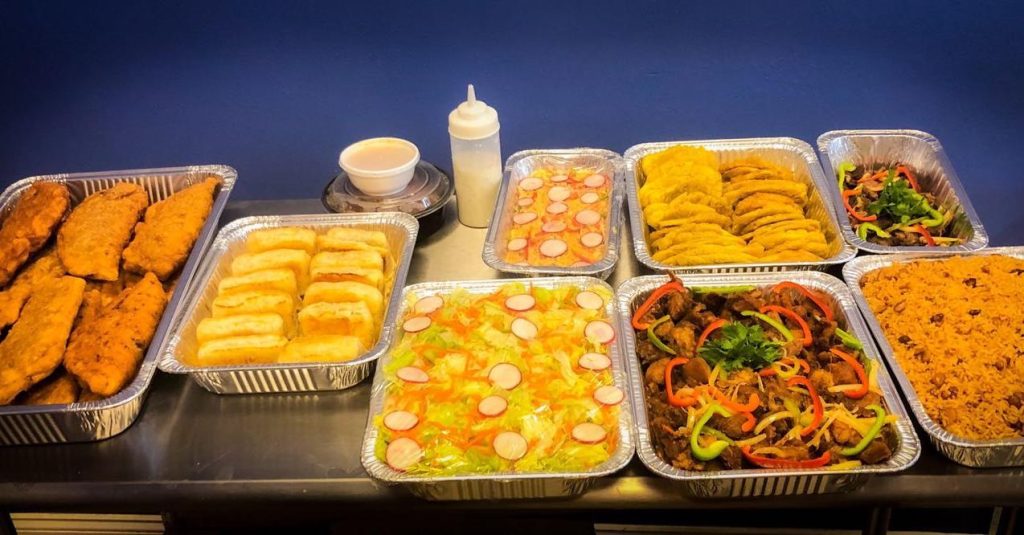 A table displaying a variety of food items served in aluminum trays.