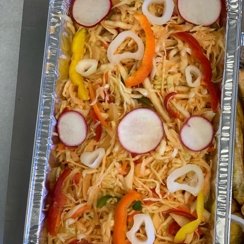 A colorful tray featuring fresh radishes, vibrant peppers, and sliced onions arranged appetizingly.