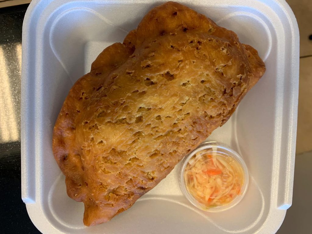 A large Haitian pies served alongside a fresh side of slaw
