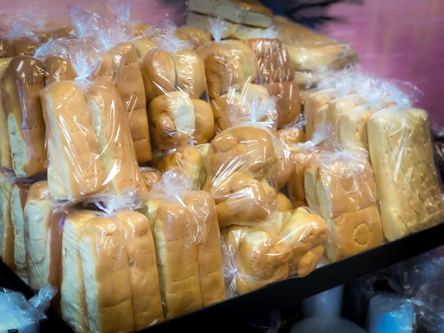 A variety of delicious breads made by La Difference Bakery & Cafe neatly arranged on a display table.